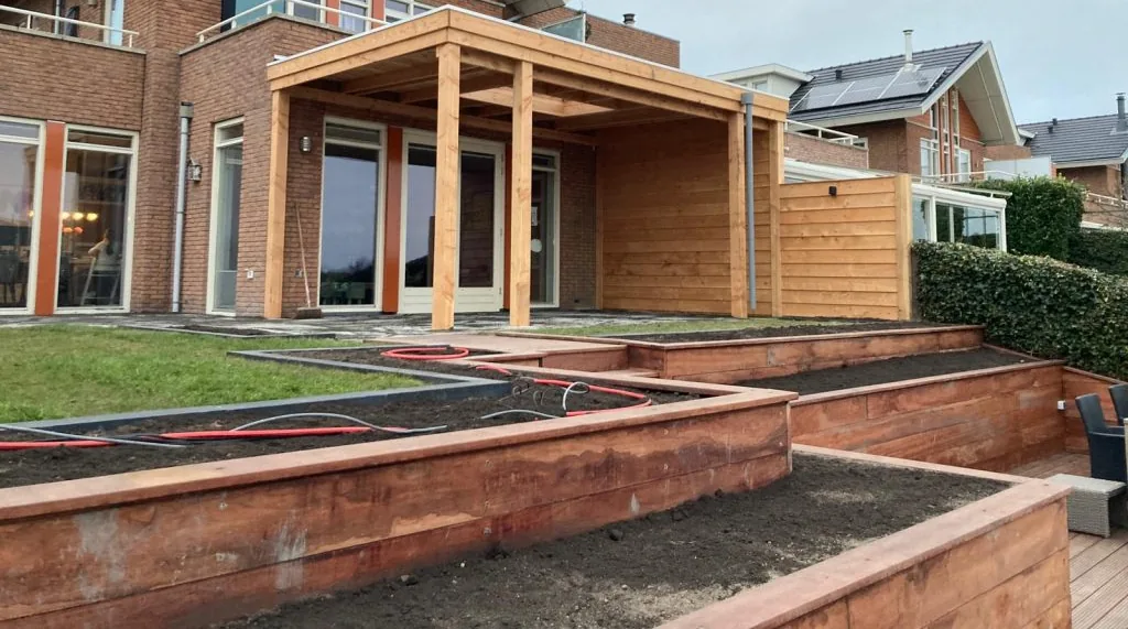 Houten aanbouw met platdak tegen de gevel van een woning